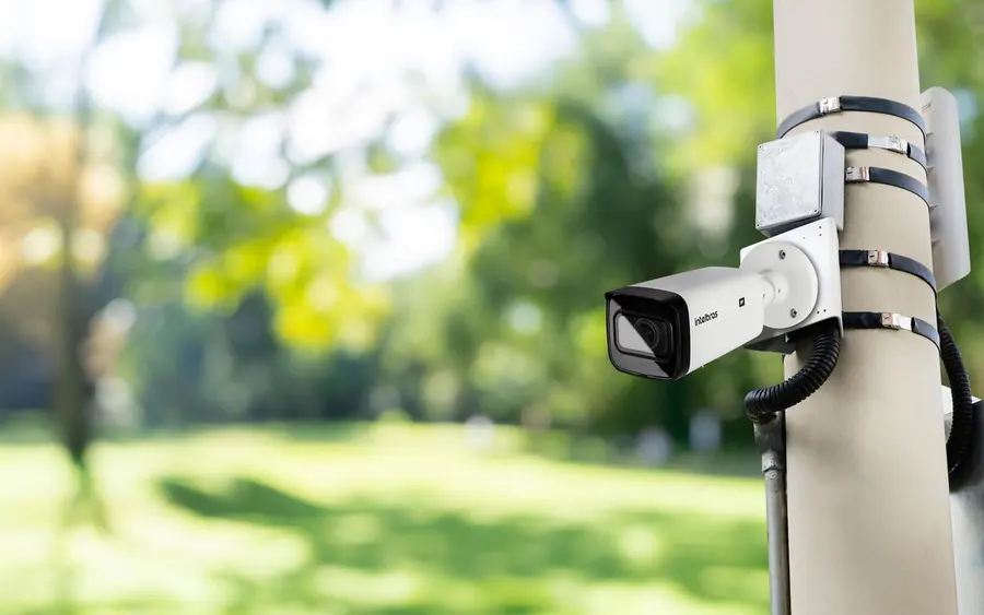 Câmera de segurança instalada em poste em área verde