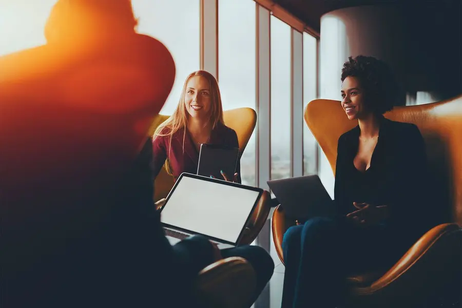 Profissionais trabalhando com notebook e tablet em um ambiente corporativo
