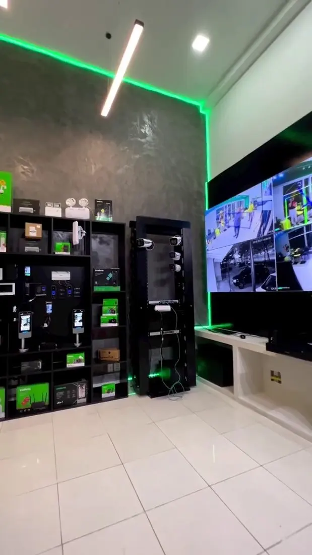 Showroom da loja conceito Telmax na Barra da Tijuca com parede de produtos Intelbras e video wall