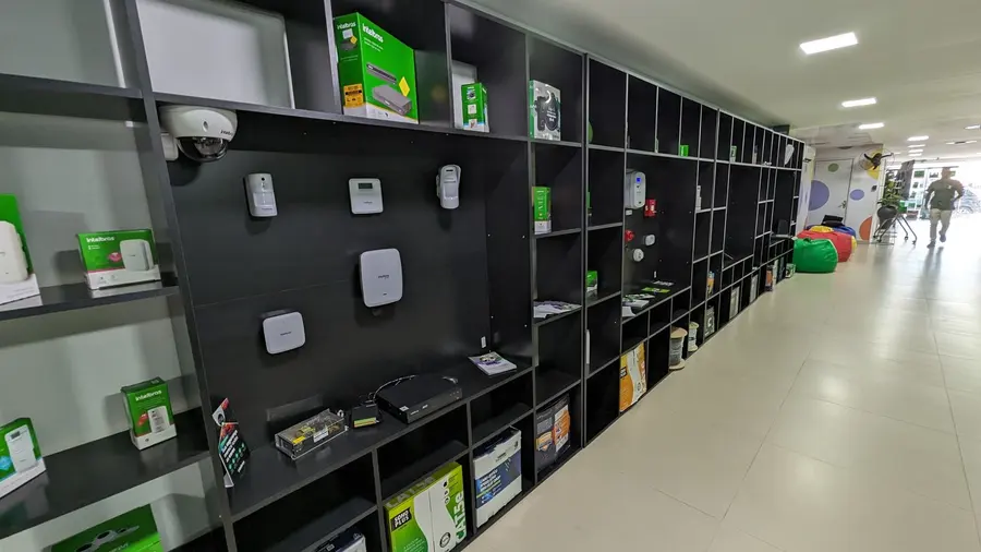 Corredor da loja Telmax com prateleiras de produtos Intelbras